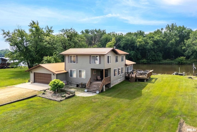 18599 317th St, Long Grove, IA 52756 - back of property featuring driveway, a lawn, a garage, and a deck with water view