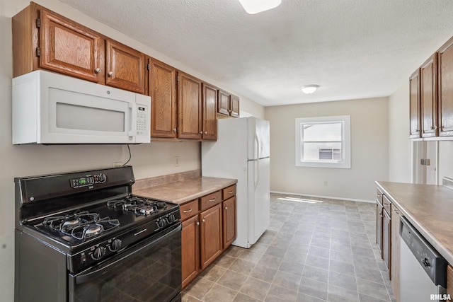 3133 W 1st St, Davenport, IA 52804 - kitchen with white appliances, brown cabinets, a textured ceiling, light tile patterned floors, and light countertops