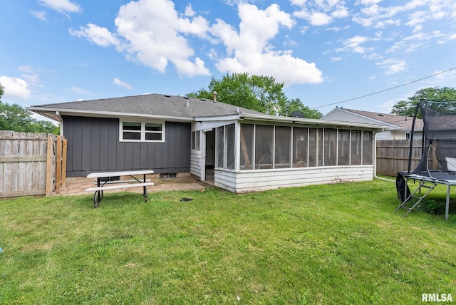 2506 Holly Dr, Bettendorf, IA 52722 - rear view of house with a trampoline, a sunroom, a fenced backyard, and a shingled roof