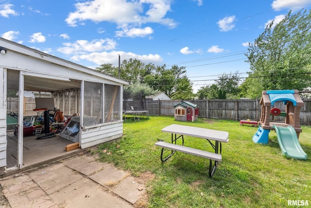 2506 Holly Dr, Bettendorf, IA 52722 - fenced backyard featuring a sunroom, a playground, a patio area, and a trampoline