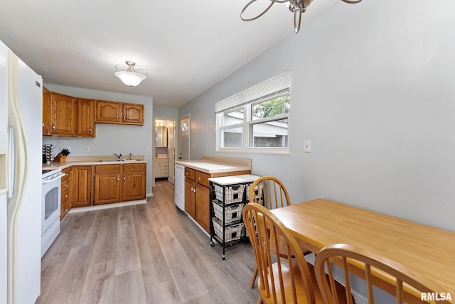 2506 Holly Dr, Bettendorf, IA 52722 - kitchen with white appliances, brown cabinets, light wood-type flooring, and light countertops