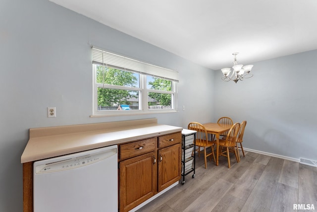 2506 Holly Dr, Bettendorf, IA 52722 - kitchen featuring white dishwasher, a chandelier, light wood-style floors, brown cabinetry, and light countertops