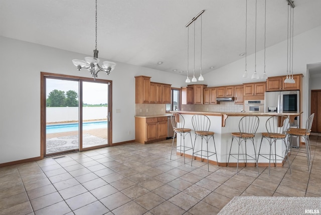 922 W Scott St, Eldridge, IA 52748 - kitchen with stainless steel appliances, tasteful backsplash, under cabinet range hood, light countertops, and lofted ceiling