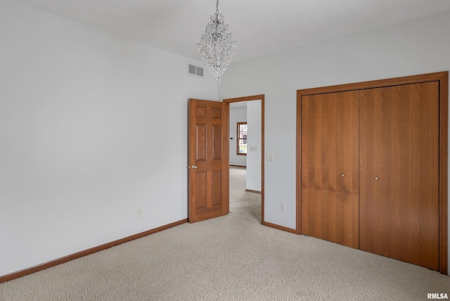 922 W Scott St, Eldridge, IA 52748 - unfurnished bedroom with carpet floors, a chandelier, and a closet