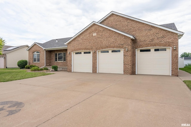 922 W Scott St, Eldridge, IA 52748 - single story home with an attached garage, brick siding, driveway, roof with shingles, and a front lawn