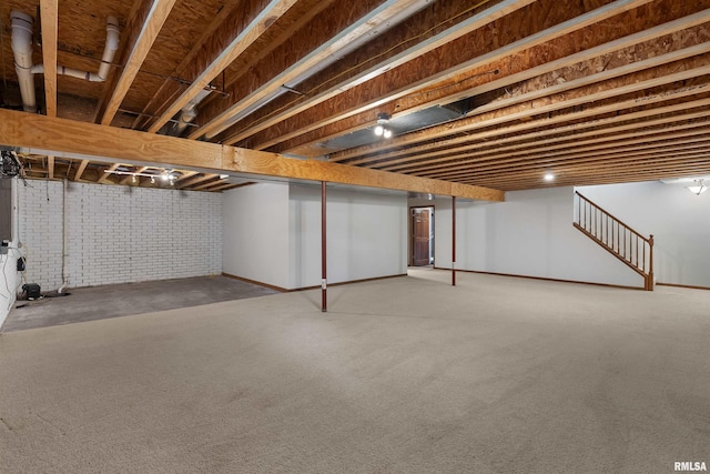 922 W Scott St, Eldridge, IA 52748 - below grade area featuring brick wall, carpet, and stairway