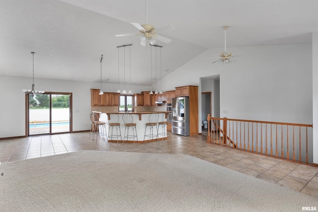 922 W Scott St, Eldridge, IA 52748 - unfurnished living room with a ceiling fan, high vaulted ceiling, a chandelier, and light tile patterned floors