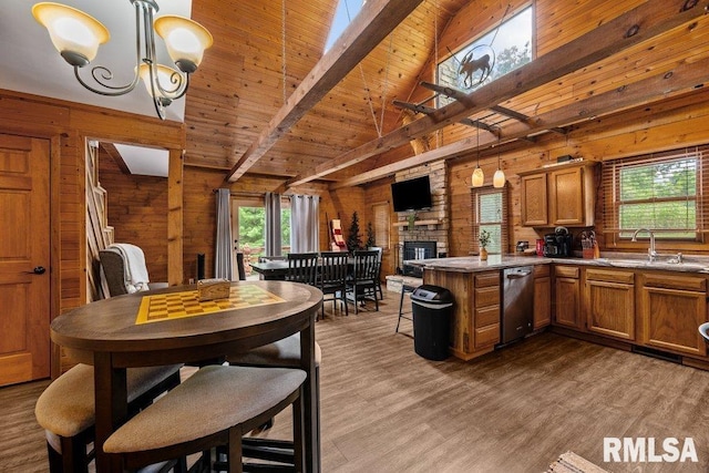 7319 106th Ave, Coal Valley, IL 61240 - kitchen featuring stainless steel dishwasher, brown cabinetry, wood walls, a peninsula, and a fireplace