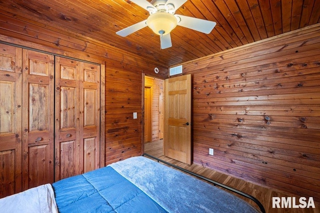 7319 106th Ave, Coal Valley, IL 61240 - bedroom with wooden walls, a closet, wooden ceiling, and ceiling fan
