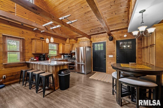 7319 106th Ave, Coal Valley, IL 61240 - kitchen with appliances with stainless steel finishes, a peninsula, wood walls, a chandelier, and dark wood-style floors