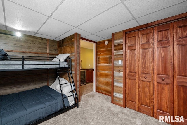 7319 106th Ave, Coal Valley, IL 61240 - unfurnished bedroom featuring wooden walls, light colored carpet, and a drop ceiling