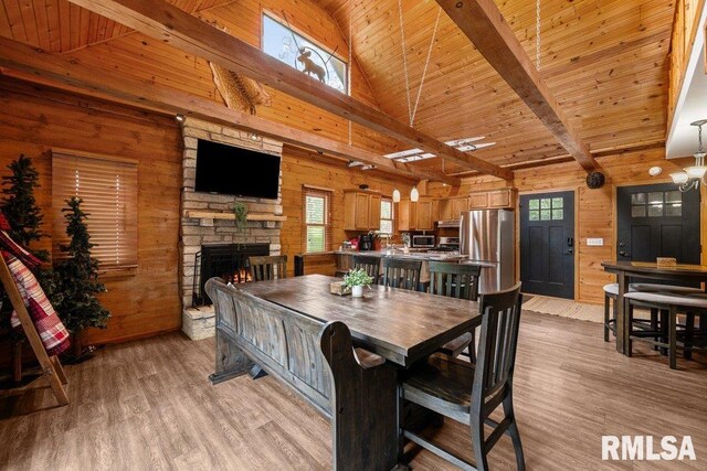 7319 106th Ave, Coal Valley, IL 61240 - dining area with wooden walls, a stone fireplace, light wood finished floors, and wood ceiling