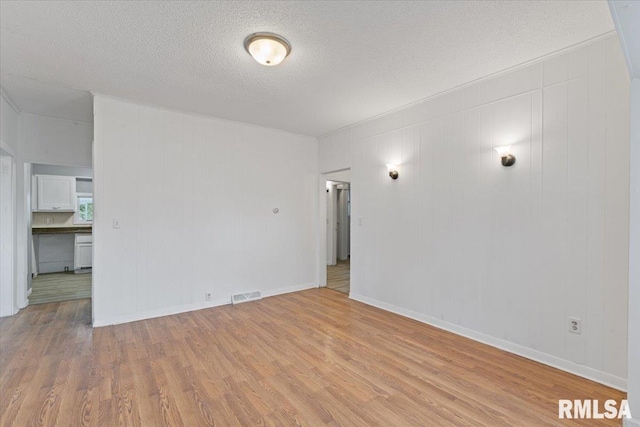3916 W Locust St, Davenport, IA 52804 - unfurnished room featuring light wood-style floors and a textured ceiling