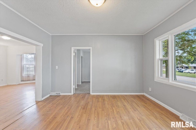 3916 W Locust St, Davenport, IA 52804 - unfurnished room with crown molding, healthy amount of natural light, light wood finished floors, and a textured ceiling