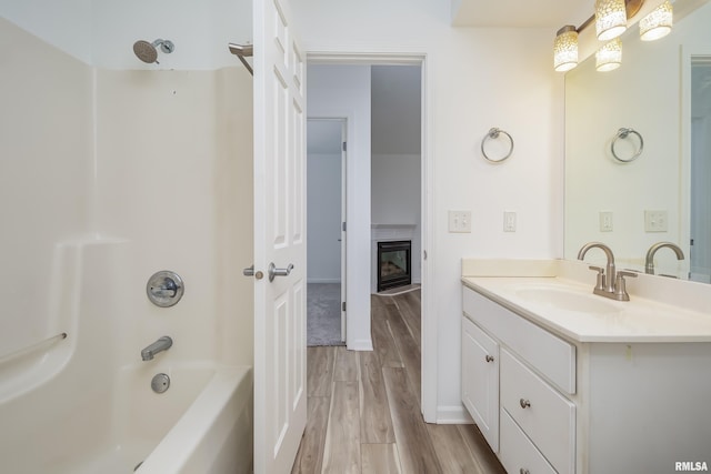 1263 33rd Avenue Cir, Silvis, IL 61282 - full bath featuring vanity, shower / bath combination, wood finished floors, and a glass covered fireplace
