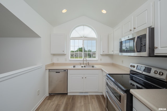 1263 33rd Avenue Cir, Silvis, IL 61282 - kitchen featuring appliances with stainless steel finishes, lofted ceiling, light wood finished floors, white cabinetry, and recessed lighting