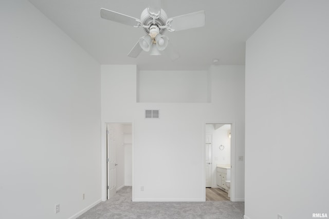 1263 33rd Avenue Cir, Silvis, IL 61282 - unfurnished bedroom featuring light carpet, a spacious closet, ensuite bathroom, a towering ceiling, and ceiling fan
