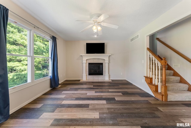 5320 Appleton Dr, Davenport, IA 52804 - unfurnished living room with wood finished floors, ceiling fan, stairs, and a tiled fireplace