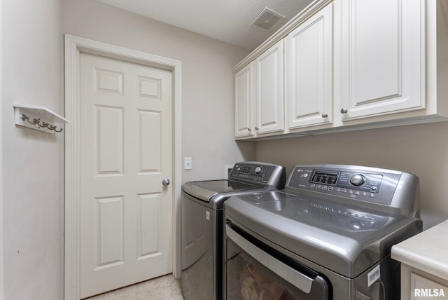 5320 Appleton Dr, Davenport, IA 52804 - laundry area with washing machine and dryer, cabinet space, and light tile patterned floors