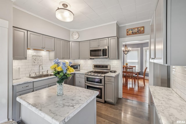 2510 Pershing Ave, Davenport, IA 52803 - kitchen with gray cabinets, stainless steel appliances, ornamental molding, hardwood / wood-style flooring, and decorative backsplash