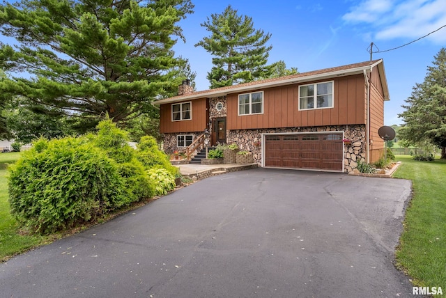 25622 1st Ave N, Hillsdale, IL 61257 - bi-level home featuring driveway, a chimney, an attached garage, and stone siding