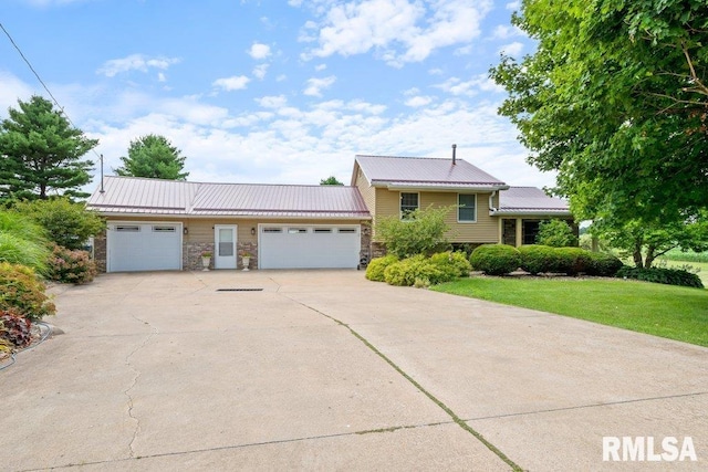 14325 139th Avenue Ct W, Taylor Ridge, IL 61284 - tri-level home with an attached garage, stone siding, concrete driveway, a metal roof, and a front lawn