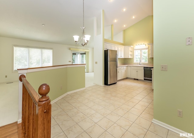3439 Maple Glen Dr, Bettendorf, IA 52722 - kitchen with freestanding refrigerator, a chandelier, black dishwasher, high vaulted ceiling, and white cabinetry