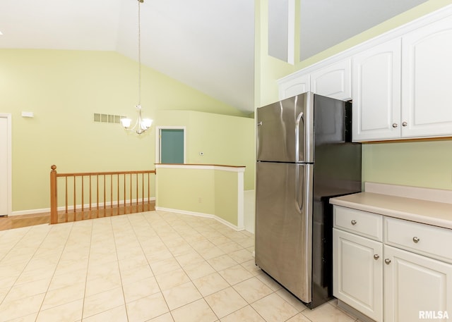 3439 Maple Glen Dr, Bettendorf, IA 52722 - kitchen featuring freestanding refrigerator, vaulted ceiling, a chandelier, white cabinetry, and decorative light fixtures
