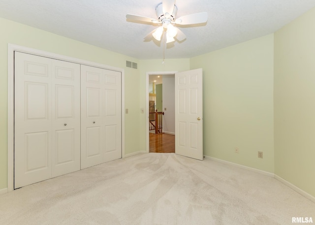 3439 Maple Glen Dr, Bettendorf, IA 52722 - unfurnished bedroom featuring carpet floors, a closet, a ceiling fan, and a textured ceiling