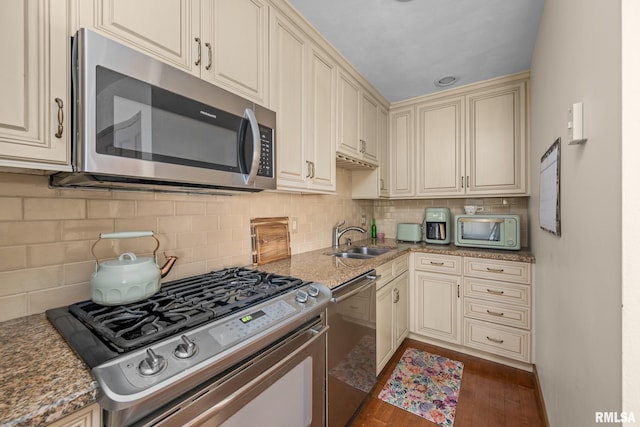 2809 12th Ave Unit 504, Rock Island, IL 61201 - kitchen featuring stainless steel appliances, cream cabinetry, dark wood-style flooring, stone countertops, and decorative backsplash