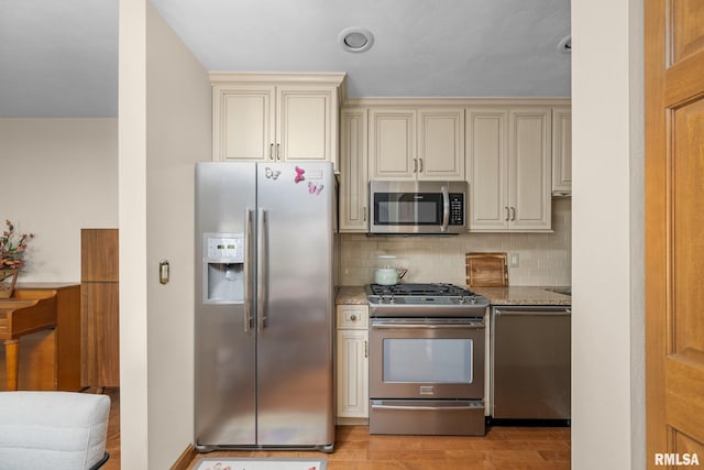 2809 12th Ave Unit 504, Rock Island, IL 61201 - kitchen with stainless steel appliances, cream cabinets, light stone countertops, and backsplash