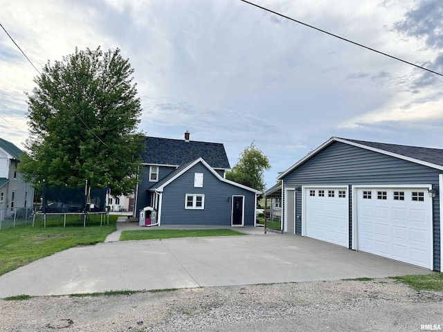 653 Ferry Rd, Miles, IA 52064 - view of front of property featuring a trampoline, a garage, driveway, and a front lawn