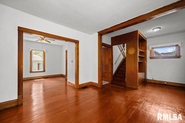 204 15th Ave, East Moline, IL 61244 - empty room with wood finished floors, stairway, and ceiling fan