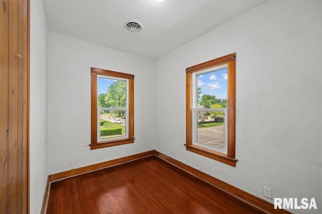 204 15th Ave, East Moline, IL 61244 - spare room featuring dark wood-type flooring and baseboards
