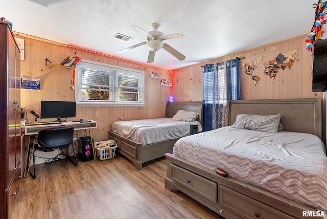 531 32nd Ave, East Moline, IL 61244 - bedroom with multiple windows, wooden walls, light wood-style flooring, an office area, and ceiling fan