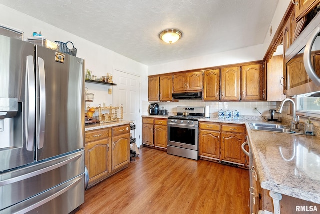 531 32nd Ave, East Moline, IL 61244 - kitchen featuring stainless steel appliances, brown cabinetry, range hood, and wood finished floors