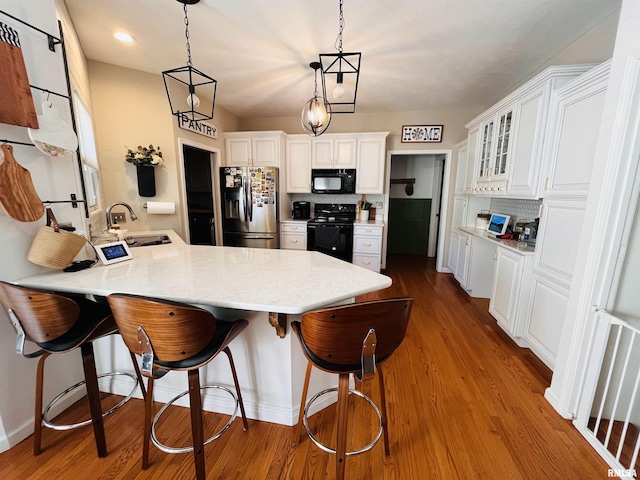 66 Windy Hill Dr, Murphysboro, IL 62966 - kitchen featuring black appliances, a peninsula, a kitchen breakfast bar, and white cabinets