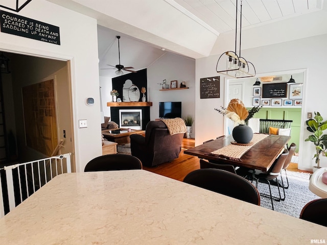 66 Windy Hill Dr, Murphysboro, IL 62966 - dining room with wood finished floors, a ceiling fan, a glass covered fireplace, and a chandelier