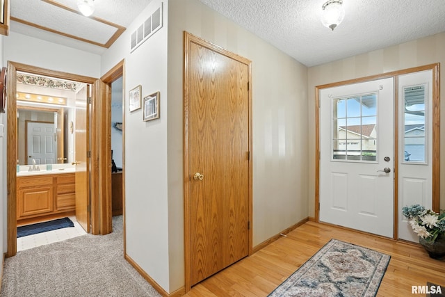 2722 Linwood Ct, Davenport, IA 52806 - foyer featuring a textured ceiling and light wood finished floors