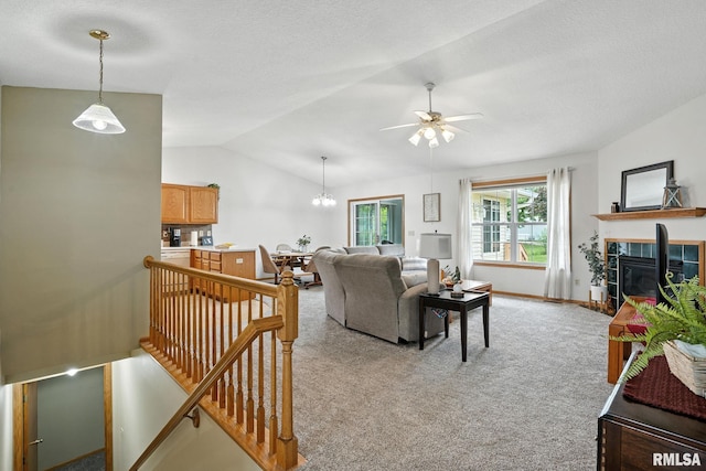 2722 Linwood Ct, Davenport, IA 52806 - living room featuring a tile fireplace, lofted ceiling, light carpet, ceiling fan, and a textured ceiling