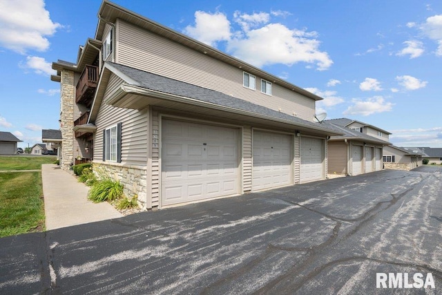 3209 S 16th Ave Unit 203, Eldridge, IA 52748 - view of home's exterior with stone siding and community garages