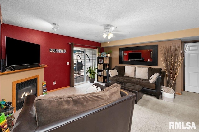 3209 S 16th Ave Unit 203, Eldridge, IA 52748 - living room with carpet floors, a ceiling fan, a glass covered fireplace, and a textured ceiling
