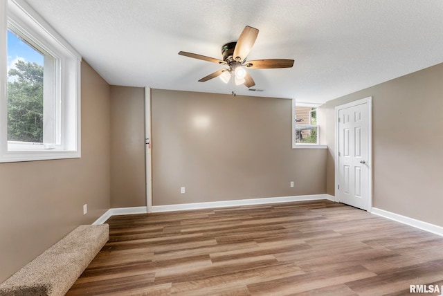 303 S Park View Dr, Park View, IA 52748 - empty room featuring a ceiling fan, healthy amount of natural light, and wood finished floors