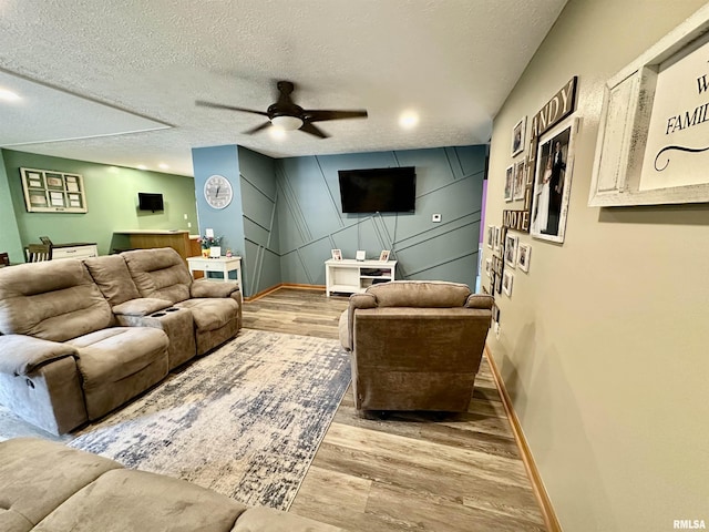 303 S Park View Dr, Park View, IA 52748 - living area featuring wood finished floors, a ceiling fan, a textured ceiling, and a decorative wall