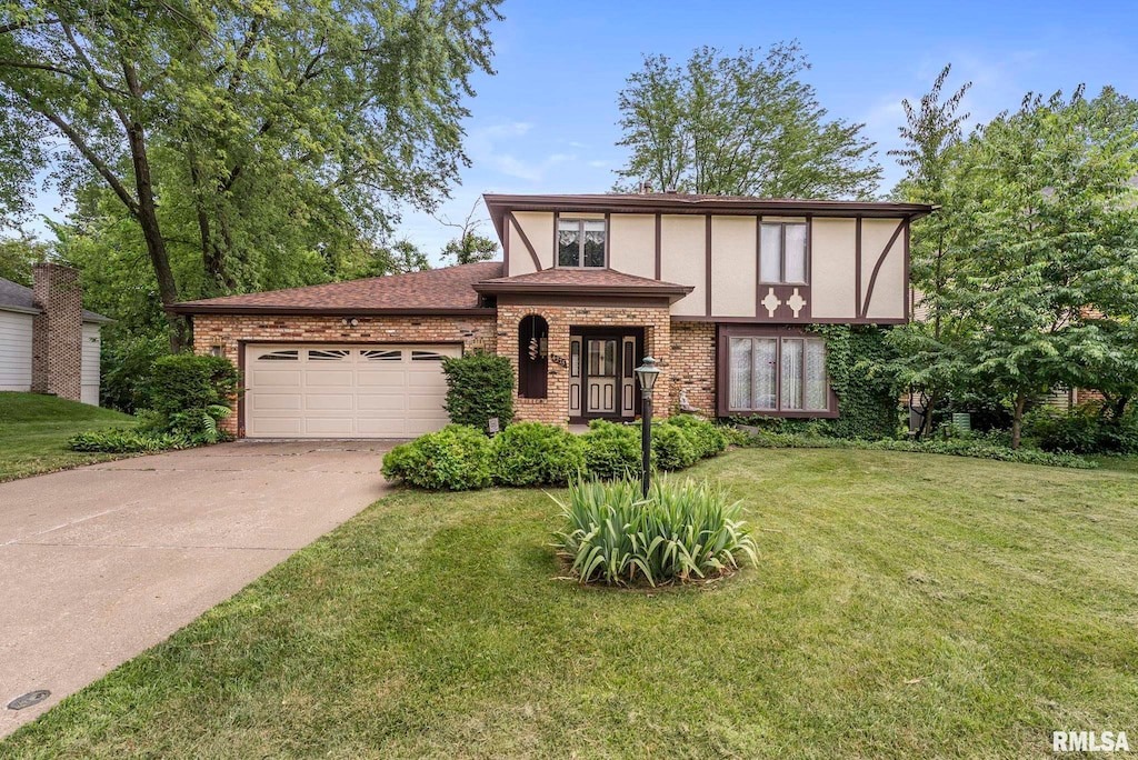 4275 Amesbury Dr, Bettendorf, IA 52722 - tudor house with brick siding, driveway, a garage, and stucco siding