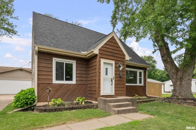 1815 Lincoln Rd, Bettendorf, IA 52722 - view of front of property with a shingled roof, a front lawn, and an outdoor structure