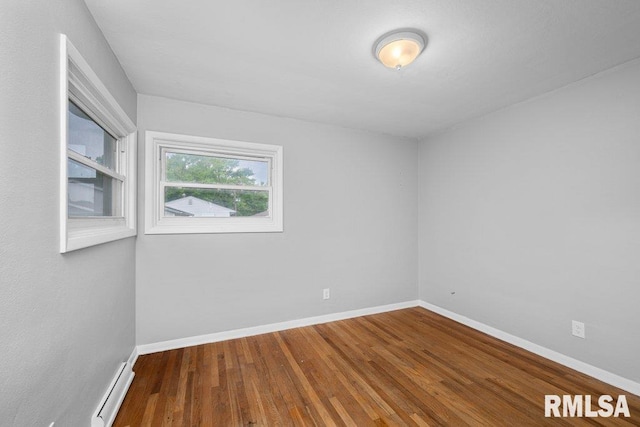 1815 Lincoln Rd, Bettendorf, IA 52722 - empty room with a baseboard heating unit and wood finished floors