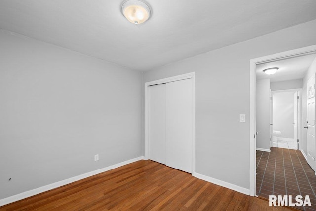 1815 Lincoln Rd, Bettendorf, IA 52722 - unfurnished bedroom featuring a closet and wood finished floors