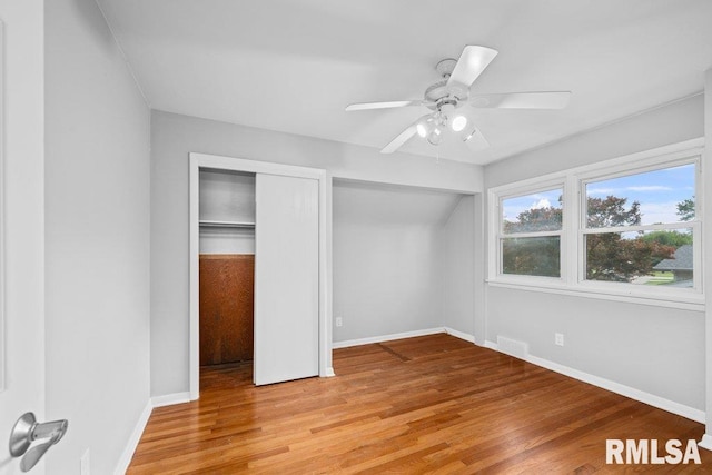 1815 Lincoln Rd, Bettendorf, IA 52722 - unfurnished bedroom featuring light wood-style flooring, a ceiling fan, and multiple closets