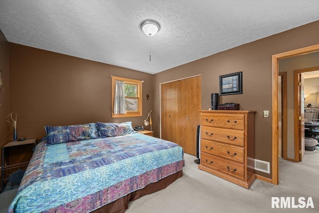 2401 W Dale Ct, Bettendorf, IA 52722 - carpeted bedroom with a closet and a textured ceiling